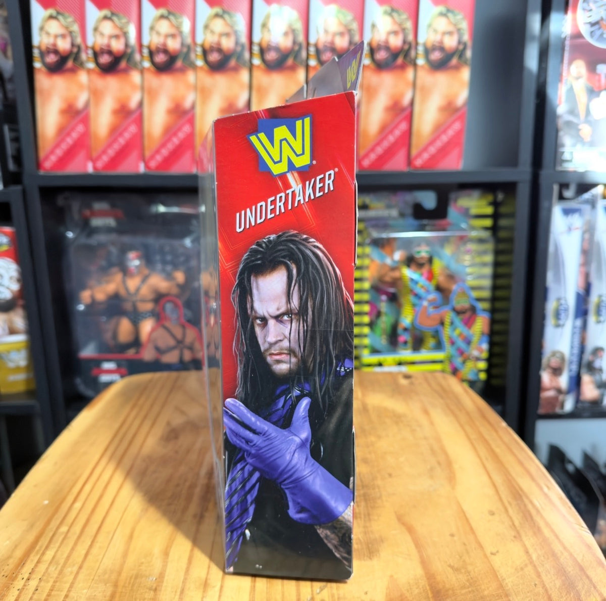 Undertaker WWE Elite boxed action figure with portrait and purple-gloved arm