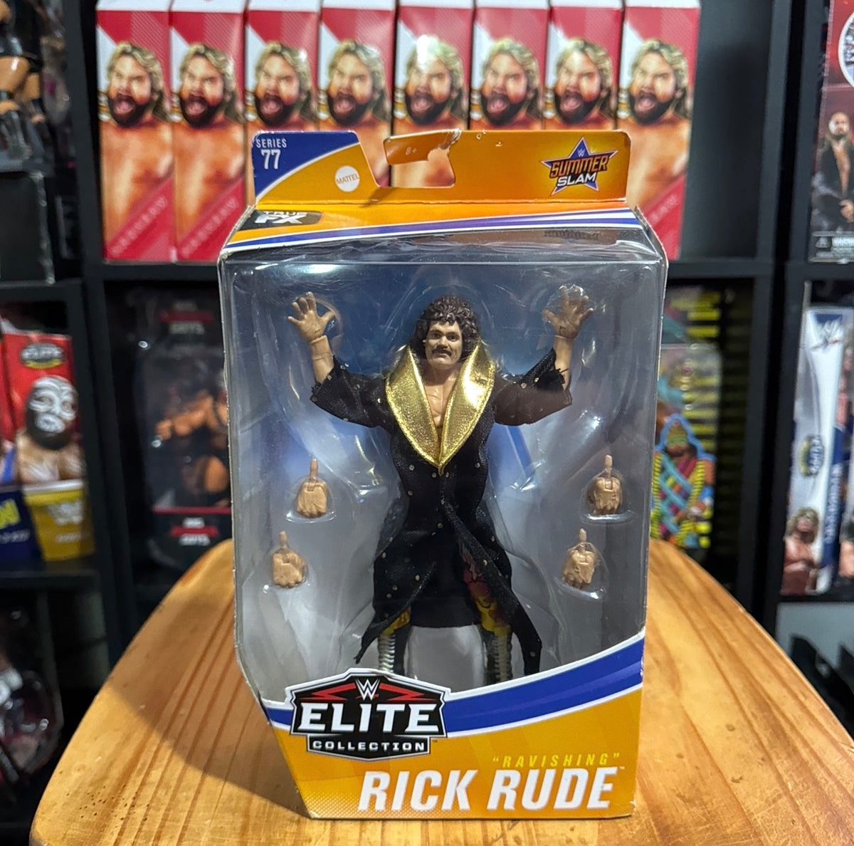 WWE Elite Collection boxed action figure standing with arms raised, gold jacket