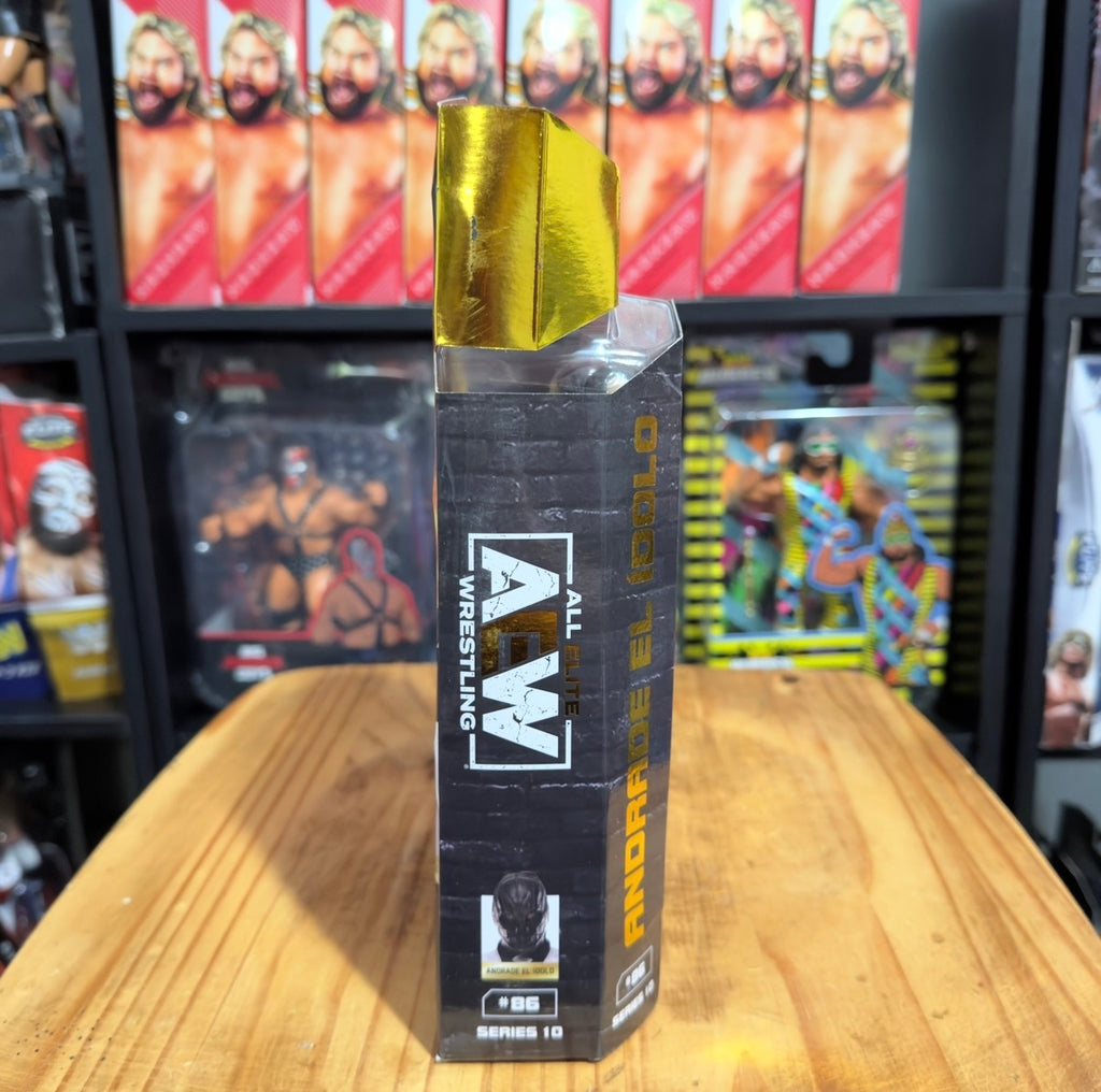 AEW wrestling figure box standing on table, gold top with black side panels