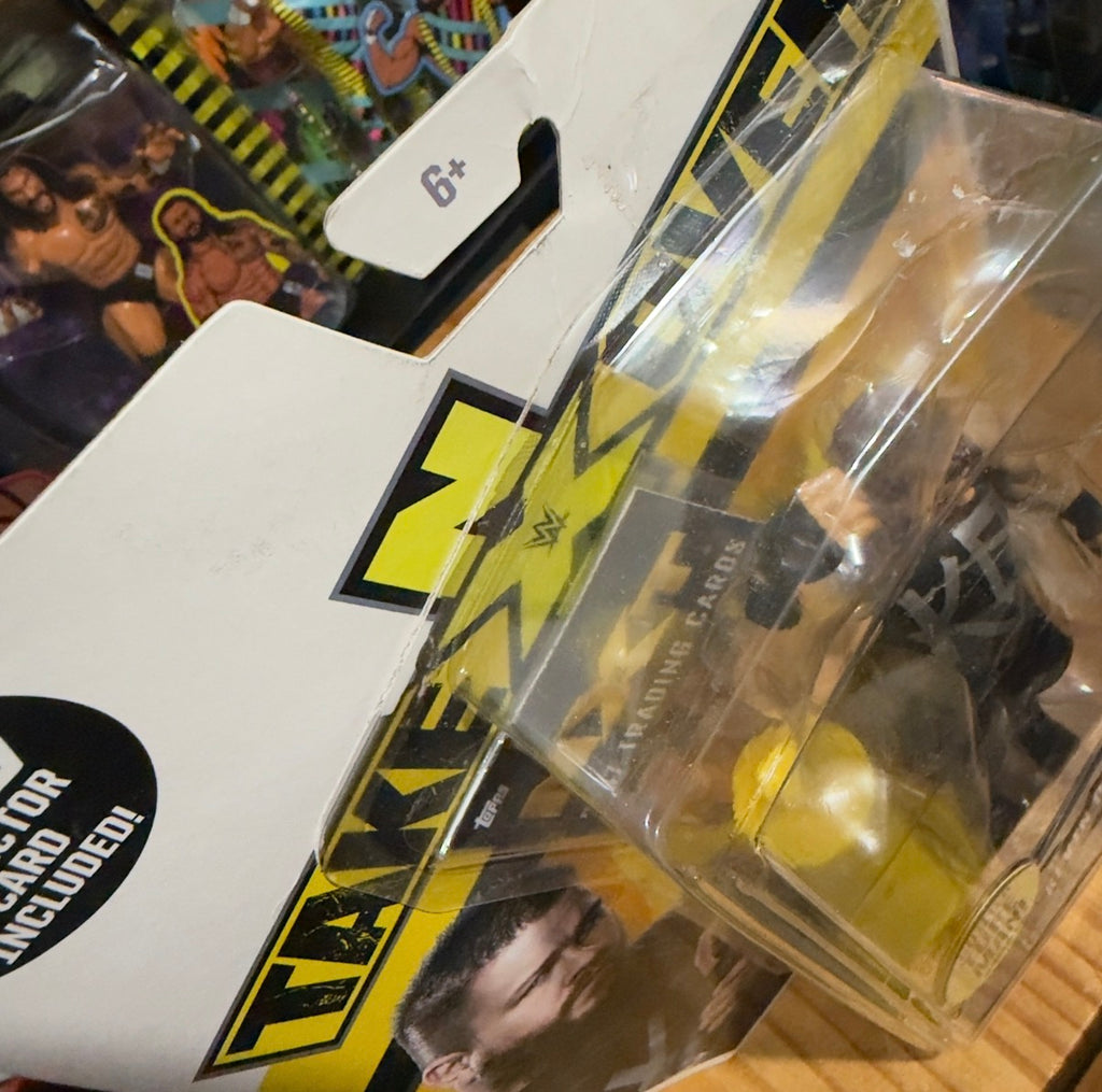 Kevin Owens action figure blister with yellow logo and clear plastic window, close-up