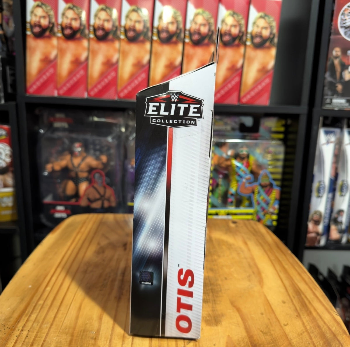 WWE Elite Series 107 Otis action figure box, vertical side view with Elite logo