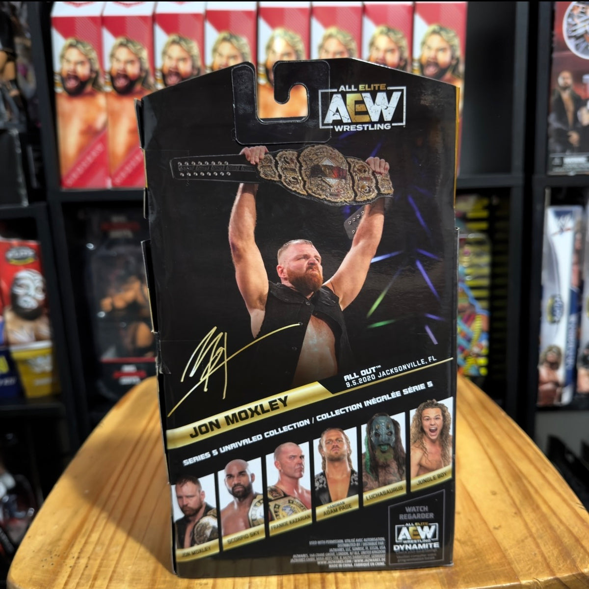 Wrestling action figure in box with AEW logo and raised-fist portrait illustration
